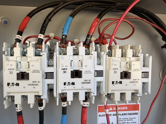 Close-up of three electrical contactors labeled EATON, each rated for 30 amps, with various colored wires connected to them.